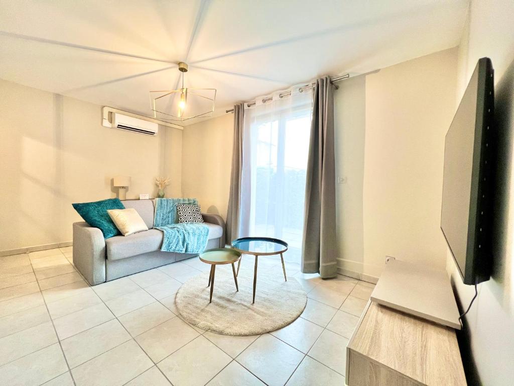 un salon avec un canapé et une télévision dans l'établissement La Bulle de Champagne, à Champagne-au-Mont-dʼOr