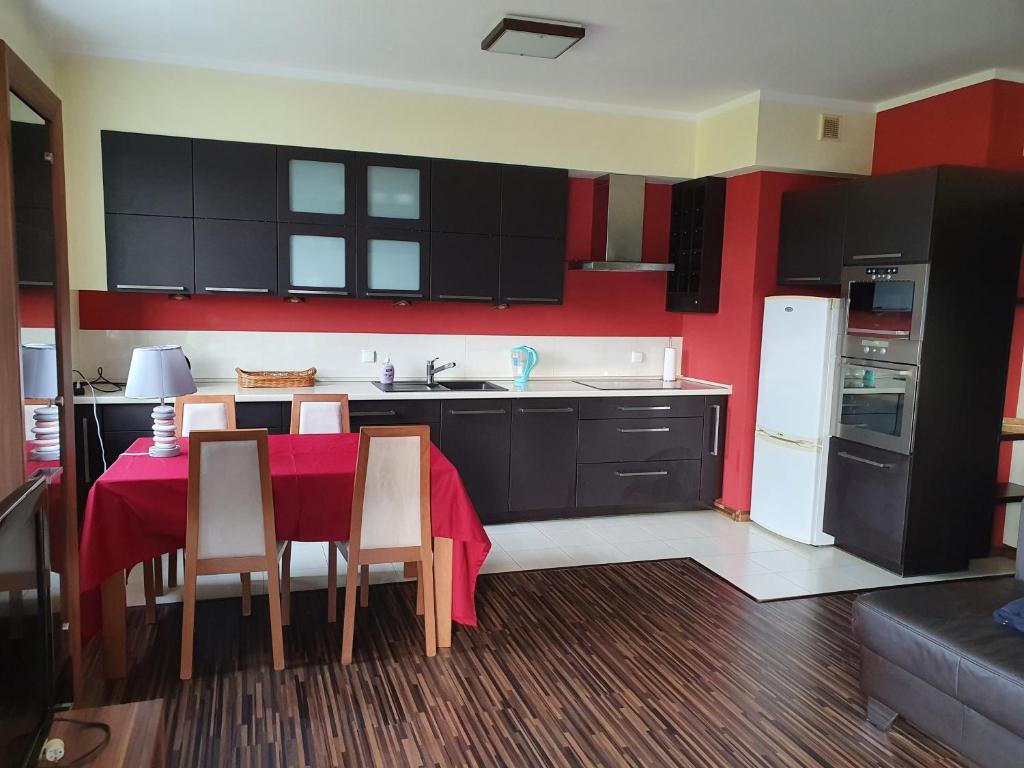 a kitchen with a table with chairs and a refrigerator at Apartament Glinki in Bydgoszcz