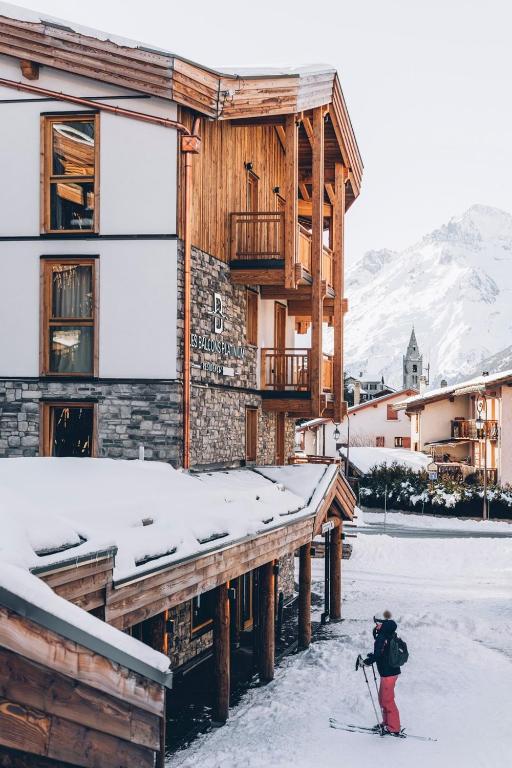 a person on skis in the snow in front of a building at Les Balcons Platinium Val Cenis in Lanslevillard