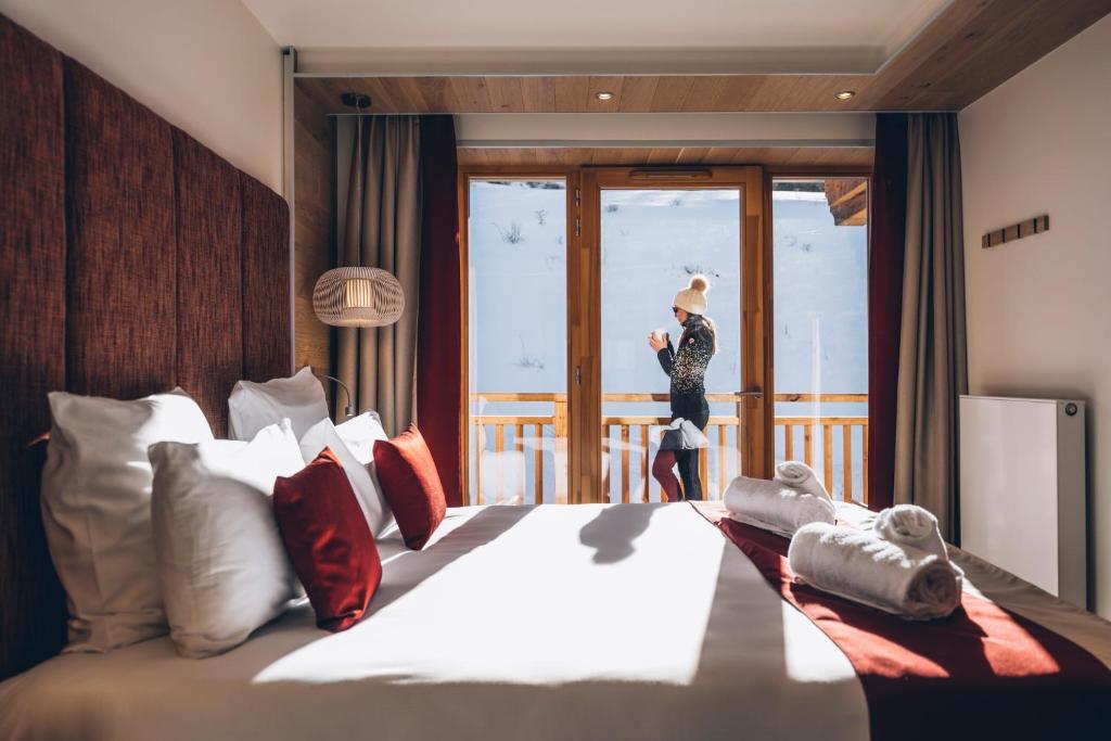 a person taking a picture of a bed in a hotel room at Les Balcons Platinium Val Cenis in Lanslevillard