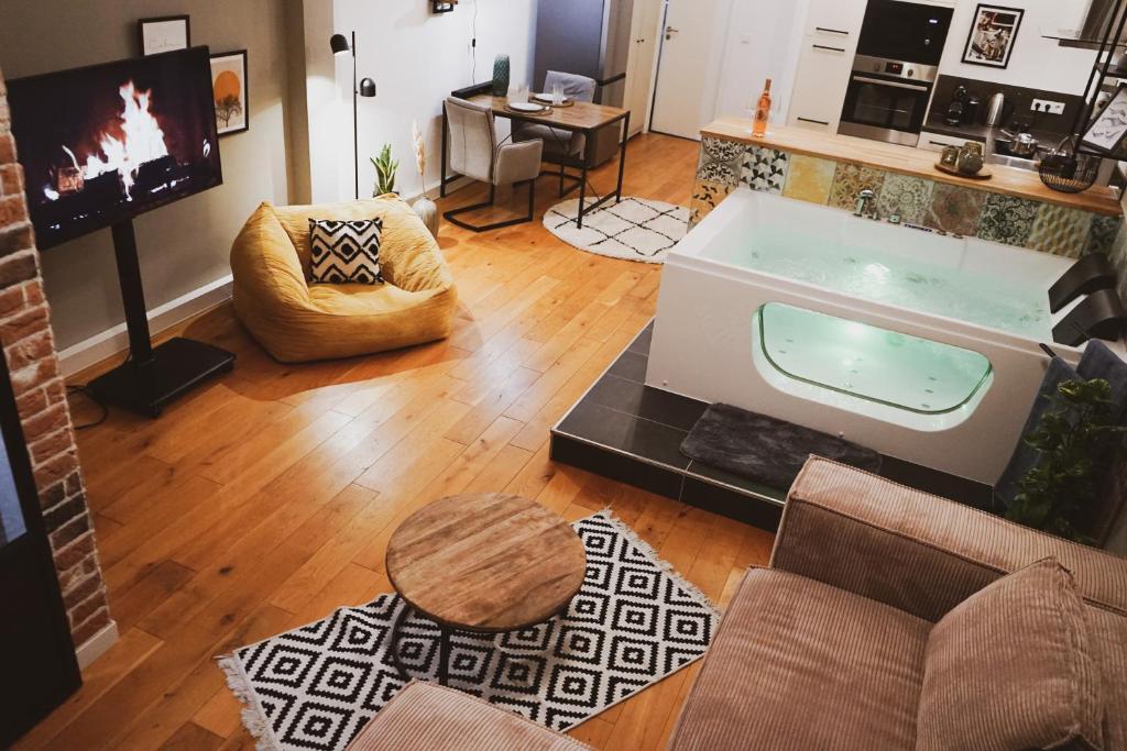 ein Wohnzimmer mit einer Badewanne in der Mitte eines Zimmers in der Unterkunft Stilvolles City-Loft mit privatem Whirlpool in Trier