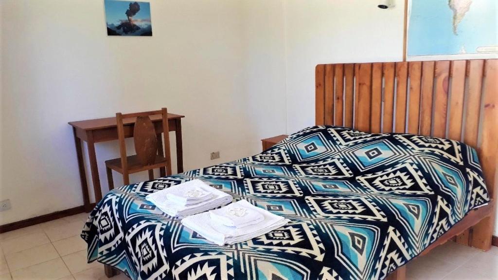 sypialnia z łóżkiem z niebiesko-białą kołdrą w obiekcie La Estancia de Runtún Km 7 w Baños