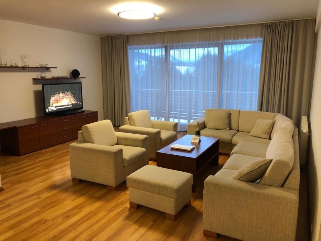 a living room with a couch and chairs and a tv at Premium 116m2 Apartment Donovaly in Donovaly