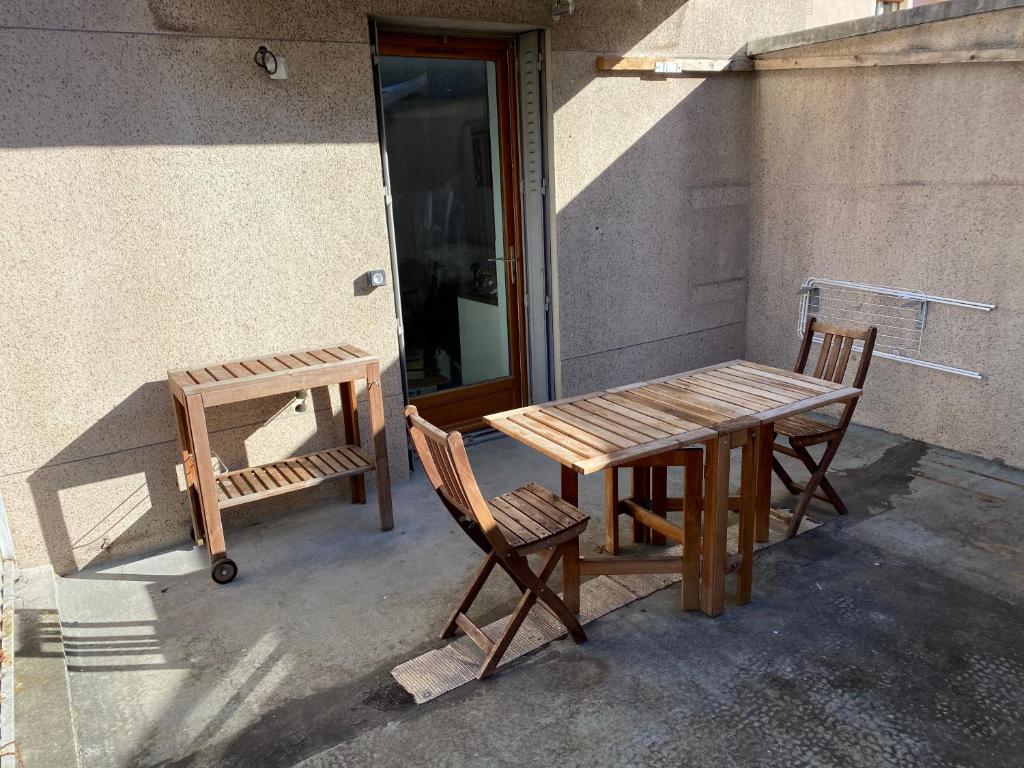 a wooden table and two chairs next to a building at Appartements VIZILLE GRENOBLE - Route Napoleon in Vizille