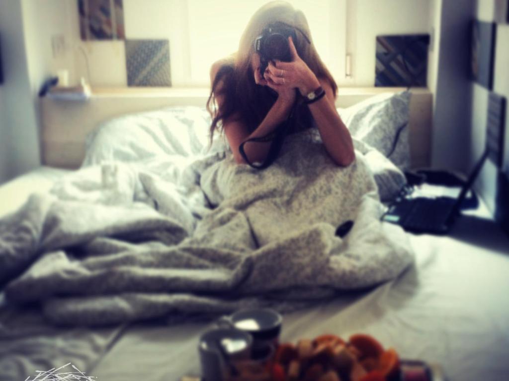 una chica sentada en una cama con una manta en The Nest / Il Nido en Polignano a Mare
