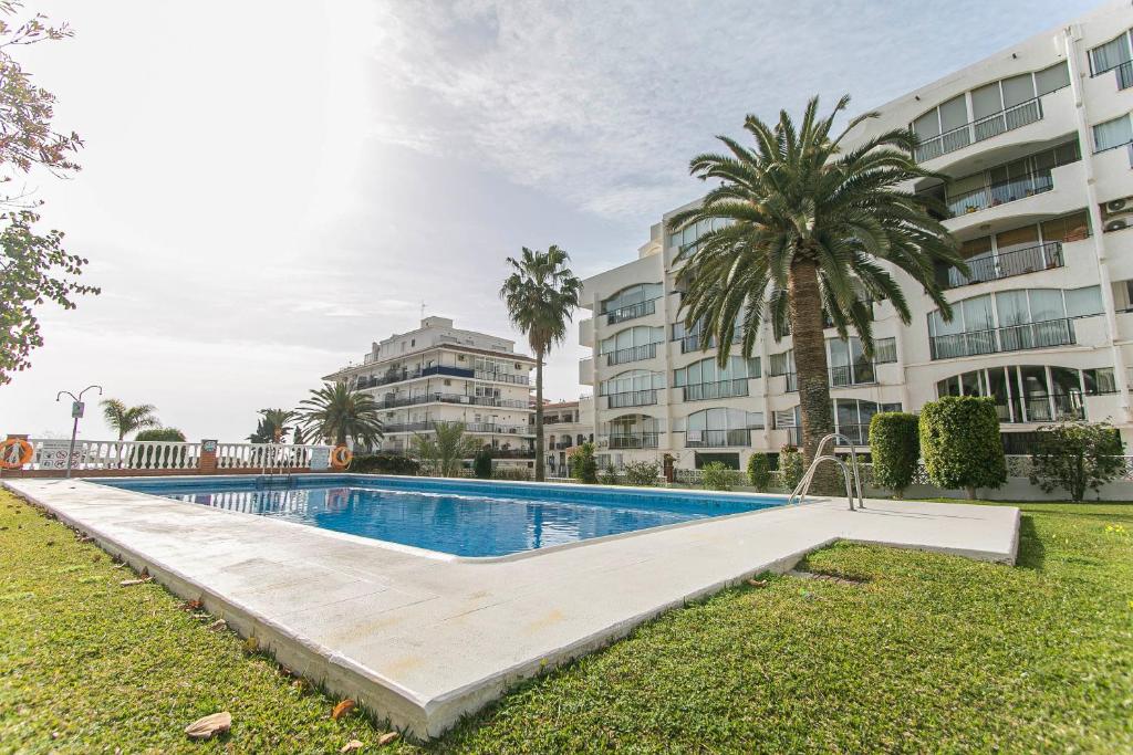 una piscina frente a un edificio en Carabeo 2 dorm Nerja en Nerja