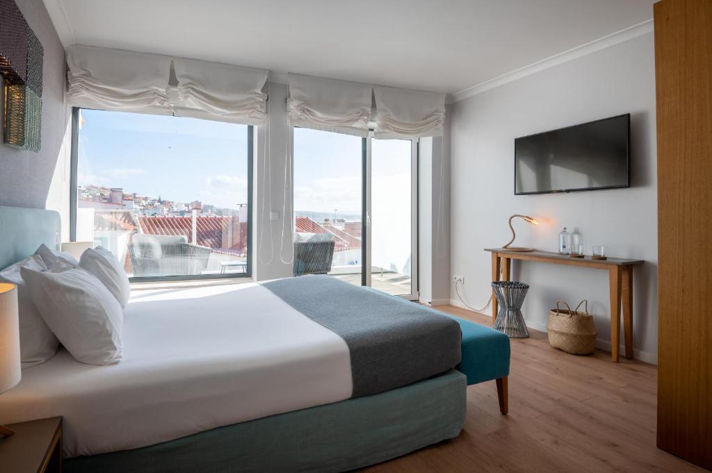 a bedroom with a large bed and a large window at Reserva FLH Hotels Ericeira in Ericeira