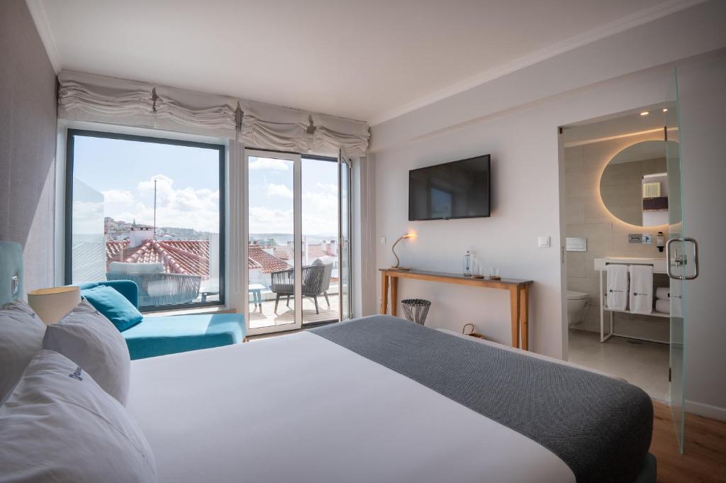 a hotel room with a bed and a large window at Reserva FLH Hotels Ericeira in Ericeira