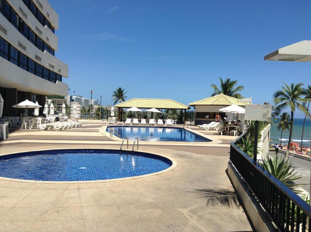 uma grande piscina ao lado de um edifício com um resort em Apartamento em Ondina em Salvador