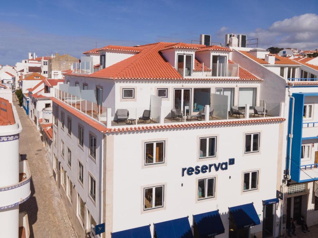 a white building with a red roof at Reserva FLH Hotels Ericeira in Ericeira