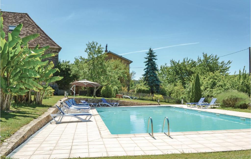 Jumilhac-le-GrandにあるStunning Home In Jumilhac With 5 Bedrooms, Private Swimming Pool And Wifiの椅子と家のある庭のスイミングプール