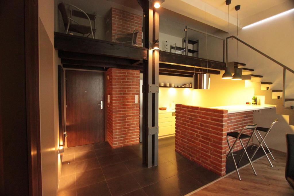 a kitchen with a brick wall and a loft at Loft Niezapominajka w Tobaco Park in Łódź