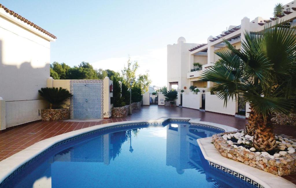basen z palmą obok budynku w obiekcie Cozy Home In Nerja With Wifi w mieście Nerja