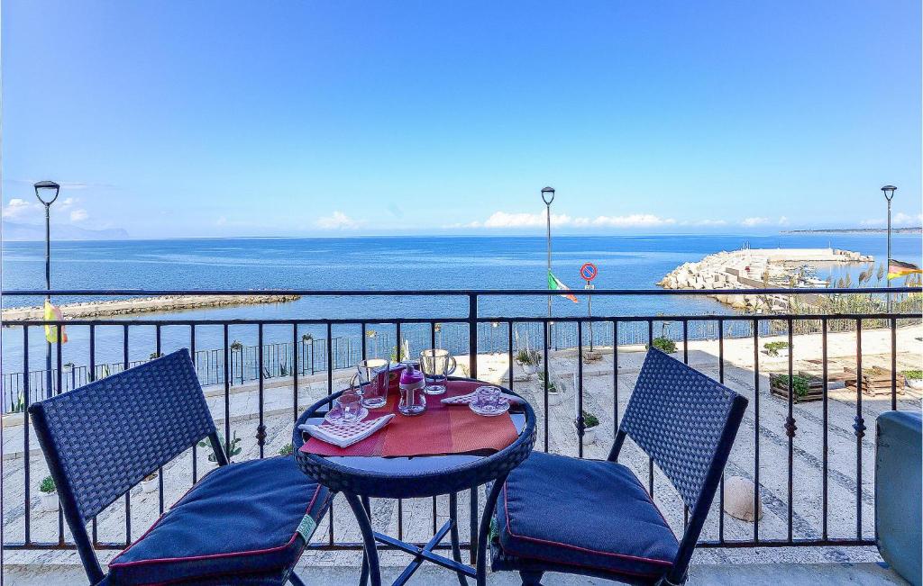 einen Tisch und Stühle auf einem Balkon mit Meerblick in der Unterkunft La Casa Sul Mare in Trappeto