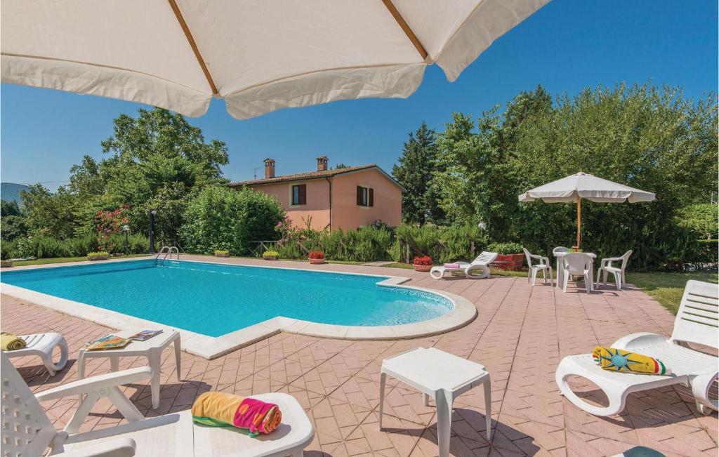 een zwembad met stoelen en een parasol bij Quadrifoglio in Configni