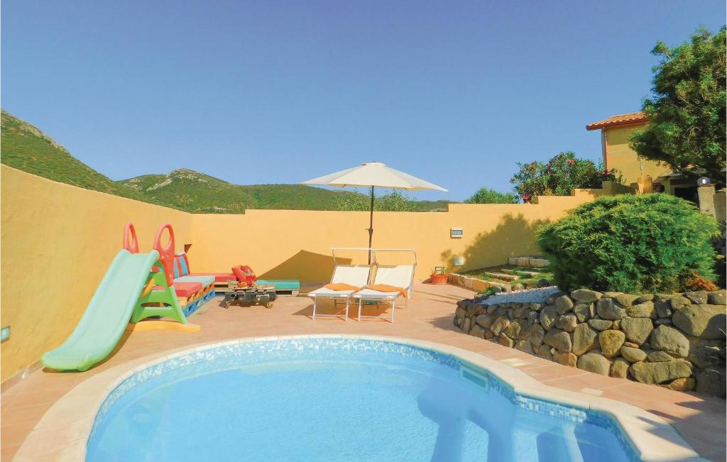 a swimming pool with a slide in a backyard at Nice Apartment In Gonnesa With Wifi in Gonnesa