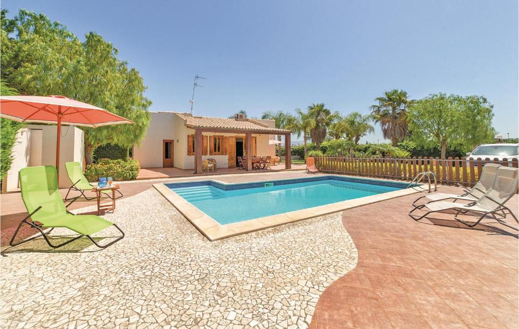 - une piscine avec 2 chaises longues et un parasol dans l'établissement Villa Anna, à Menfi