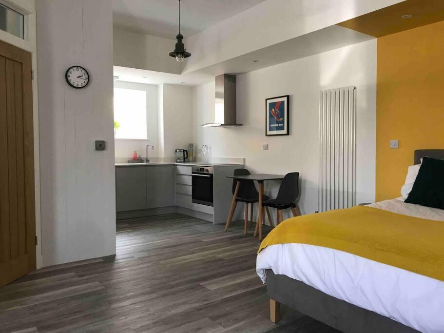 1 dormitorio con 1 cama y cocina con mesa en Goring Beach Studio - 2 min walk from seafront, en Goring by Sea
