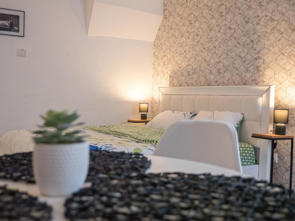 a bedroom with a bed and a plant on a table at Melion Historical Center Apartment in Sibiu