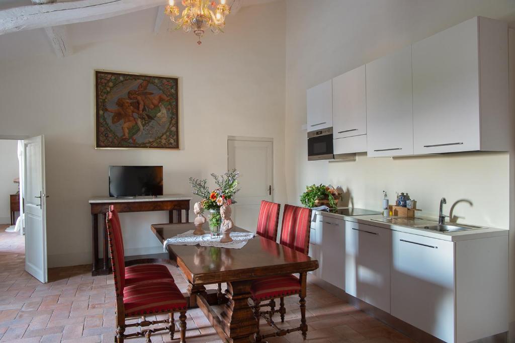 a kitchen with a table and a kitchen with white cabinets at La Corte del Castello di San Michele in San Michele in Teverina