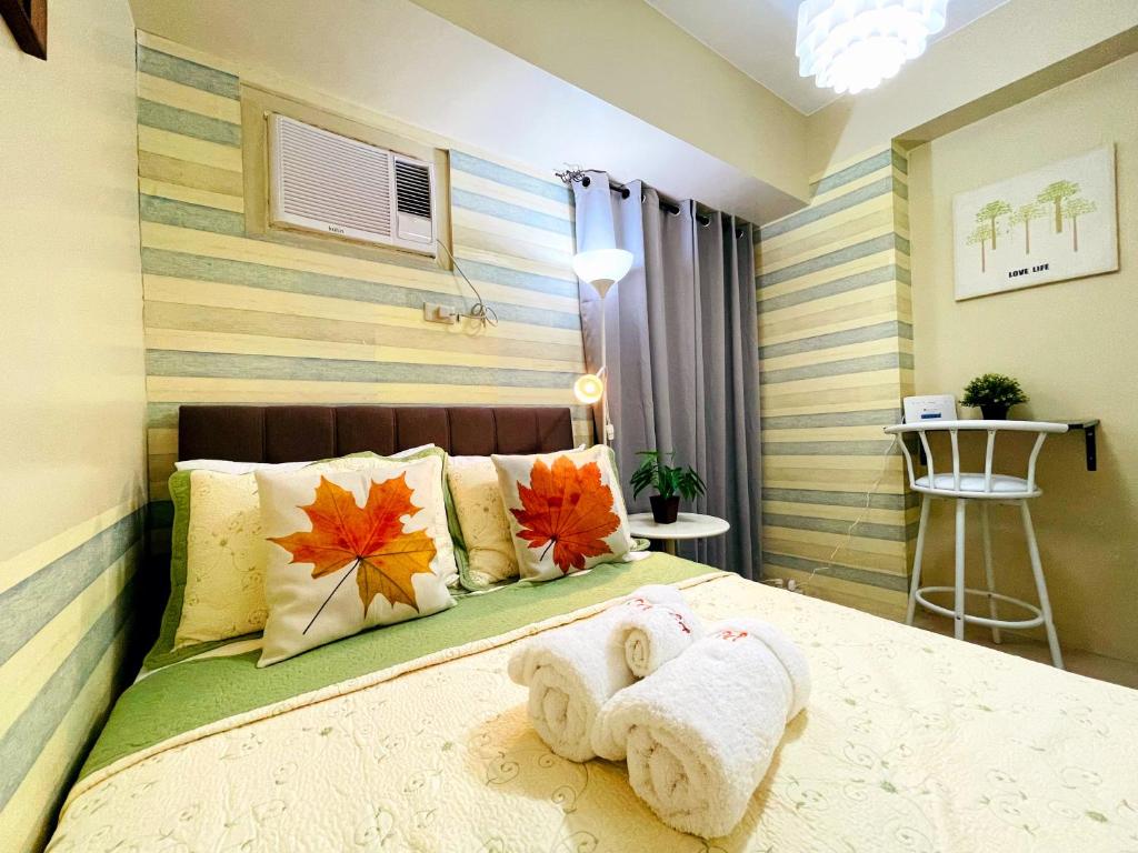 een slaapkamer met een bed met handdoeken erop bij 1-Bedroom Nordic Staycation Astrea Tower Avida, QC in Manilla