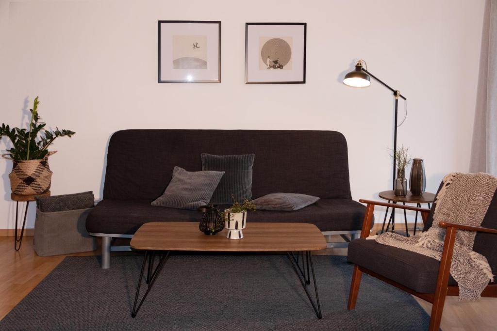 ein Wohnzimmer mit einem Sofa und einem Tisch in der Unterkunft Ferienwohnung Bruderwald in Bamberg