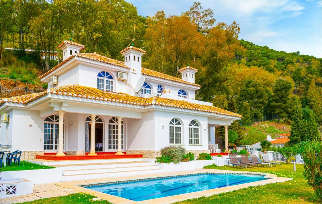 ein weißes Haus mit einem Pool davor in der Unterkunft Villa Mari in Mijas