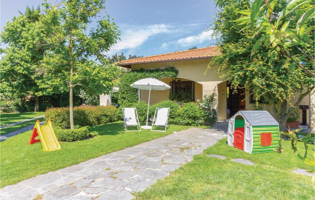 カマイオーレにあるCasa Della Margheritaの芝生の椅子2脚と家のある庭