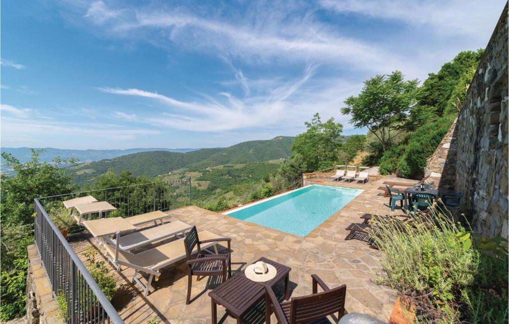uma piscina com mobiliário de pátio e vista para as montanhas em Casetta 3 em Loro Ciuffenna