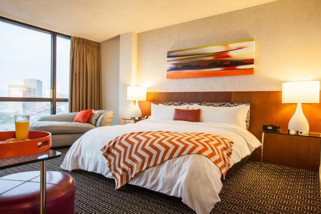 a hotel room with a bed and a couch at Hotel Derek Houston Galleria in Houston