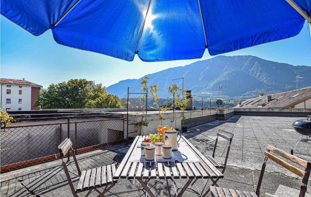 einen Tisch und Stühle auf einem Balkon mit Sonnenschirm in der Unterkunft Beautiful Apartment In Feltre With Kitchen in Feltre