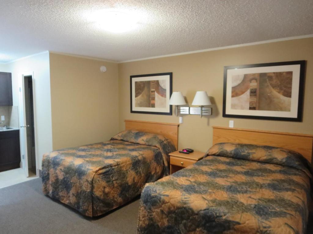 a hotel room with two beds and a television at Best Maple Inn - Drayton Valley in Drayton Valley