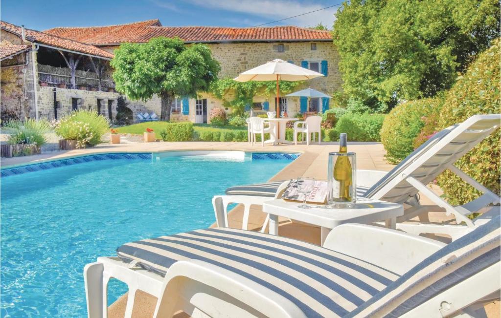 una piscina con sillas y una mesa con una botella de vino en Awesome Home In Suaux With 6 Bedrooms, Wifi And Private Swimming Pool, en Chichiat