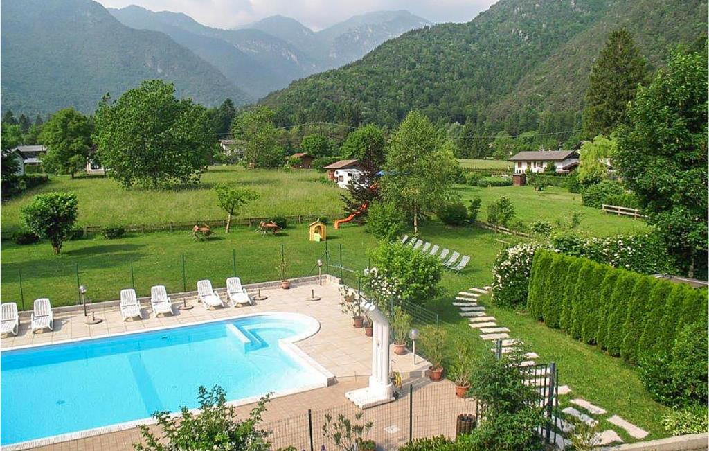 uma piscina num quintal com montanhas ao fundo em Gorgeous Apartment In Ledro With Outdoor Swimming Pool em Ledro