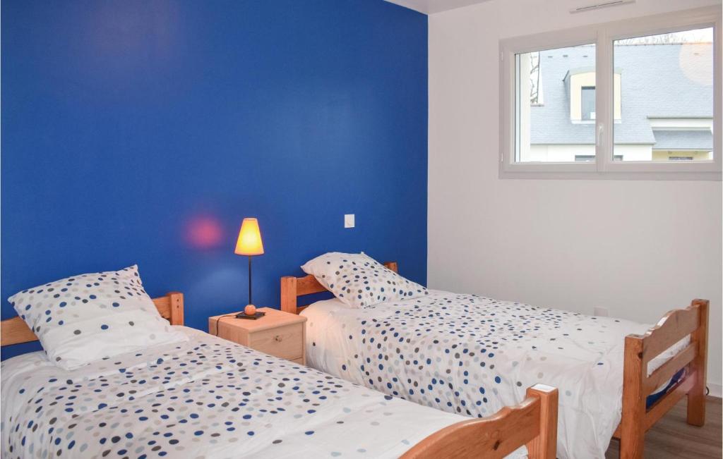 2 camas en un dormitorio con una pared azul en 3 Bedroom Beautiful Home In Matignon, en Matignon