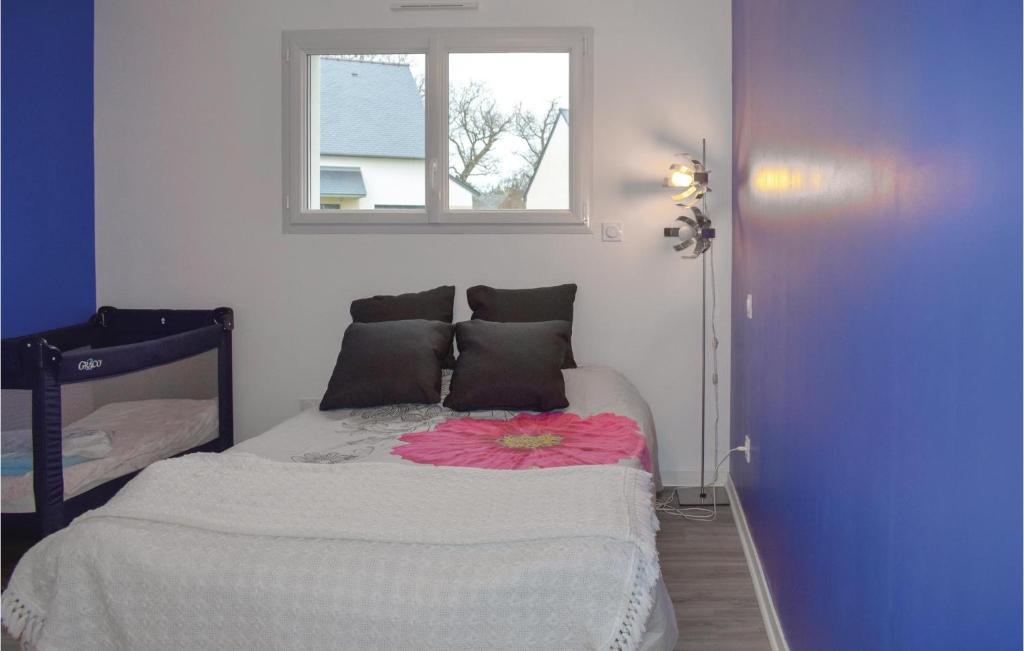 Un dormitorio con una cama con una flor rosa. en 3 Bedroom Beautiful Home In Matignon, en Matignon
