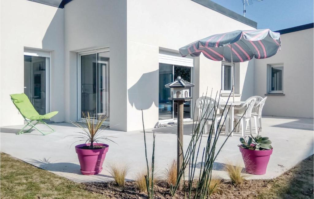 un patio con mesa, sombrilla y sillas en 3 Bedroom Beautiful Home In Matignon, en Matignon