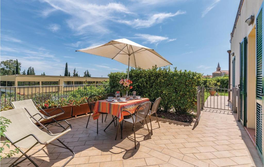 un patio con una mesa y una sombrilla en Faraldi, en San Bartolomeo al Mare