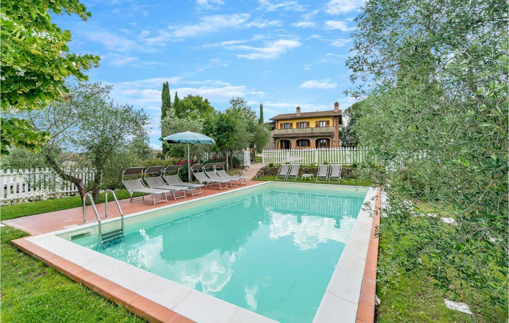 una piscina con sillas y una casa en el fondo en Villa Valle Doro, en Selvatelle