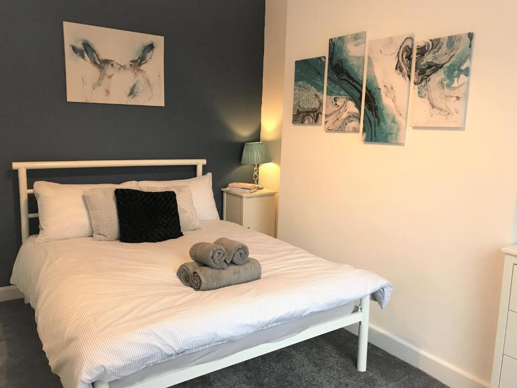 un dormitorio con una cama con dos animales de peluche en Stylish modern 3-bed house nr Manchester city ctr, en Whitefield