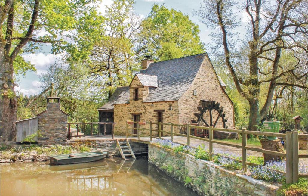 a house on a river with a boat in it at 2 Bedroom Nice Home In La Gacilly in La Gacilly
