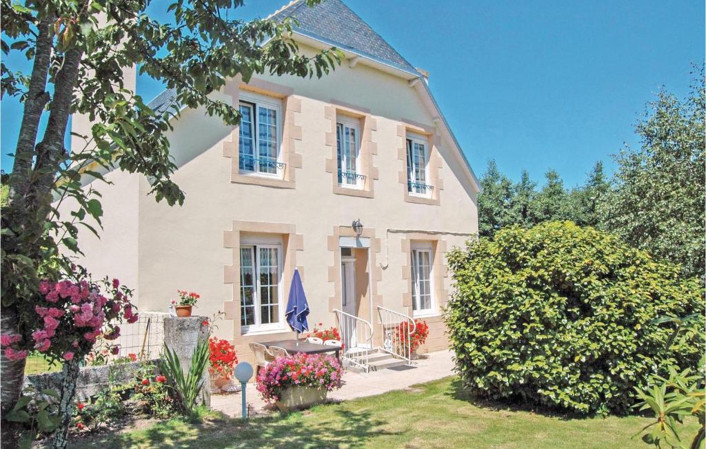 a large white house with a yard with flowers at Holiday Home Saint Jean-Trolimon - 02 in Saint-Jean-Trolimon