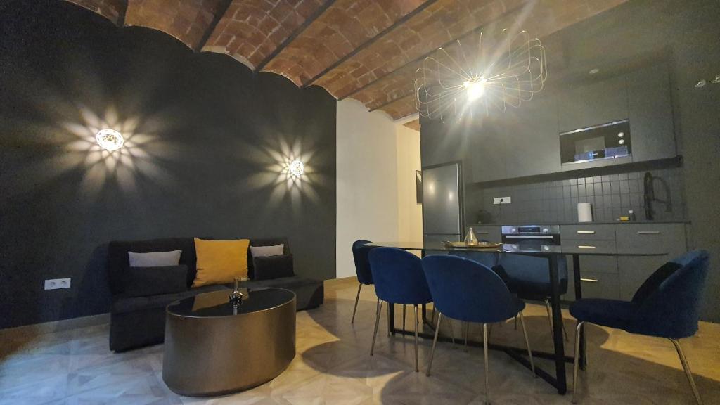 Barrio Gotico Apartments Escudellers في برشلونة: غرفة معيشة مع أريكة وطاولة وكراسي