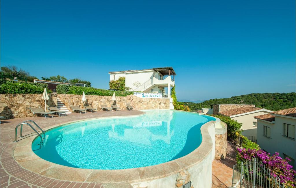 a swimming pool with chairs and a house in the background at Trilo 6 in Baja Sardinia