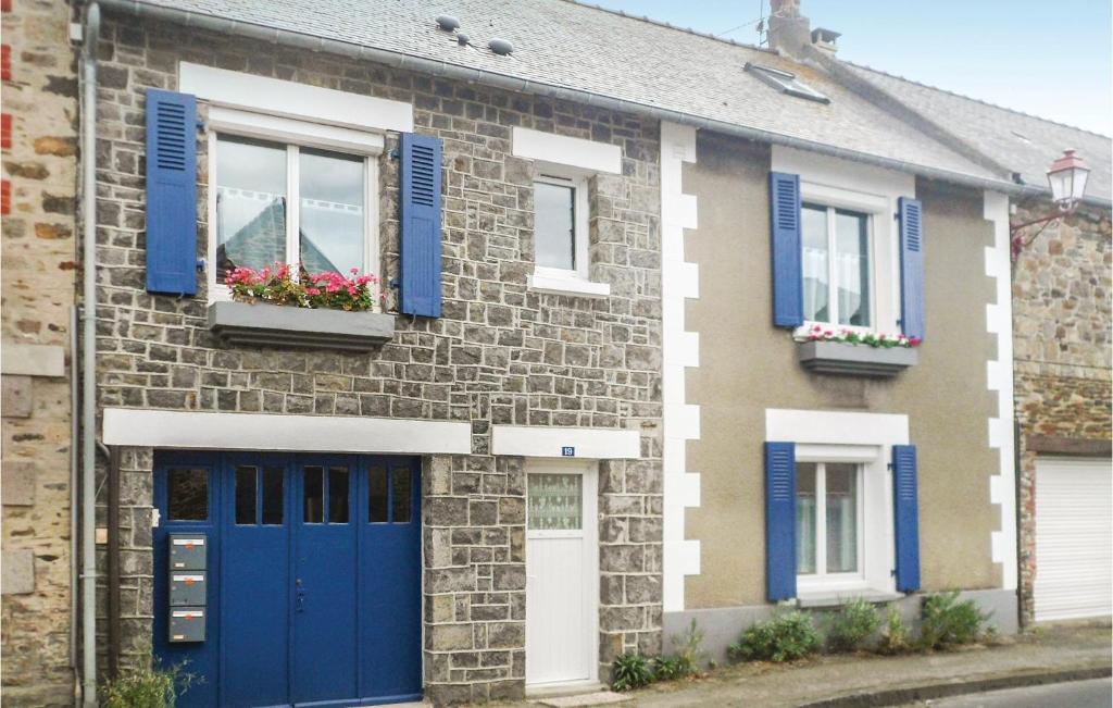 サン・ブノワ・デ・ゾンドにあるBeautiful Apartment In Vild-la-marine, Hirel With 2 Bedroomsの青いシャッターと花が咲くレンガ造りの家