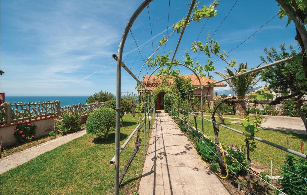 un jardin avec une clôture et l'océan en arrière-plan dans l'établissement Stunning Apartment In Porto Alabe With House Sea View, à Magomadas