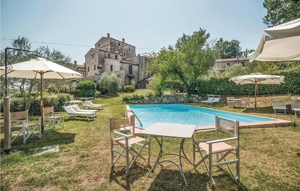 a pool with chairs and a table and umbrellas at Alabarda in Vasciano Nuovo