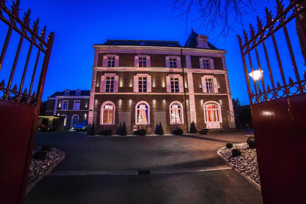 un vieux bâtiment avec une porte en face dans l'établissement The Originals Boutique, La Maison Rouge, Lens Ouest (Qualys-Hotel), à Noeux-les-Mines