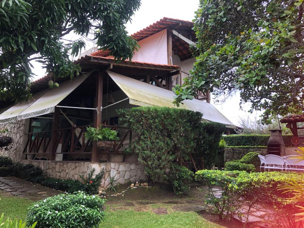 ein Haus mit einer Veranda und Stühlen im Hof in der Unterkunft Horizonte da serra 1 in Gravatá