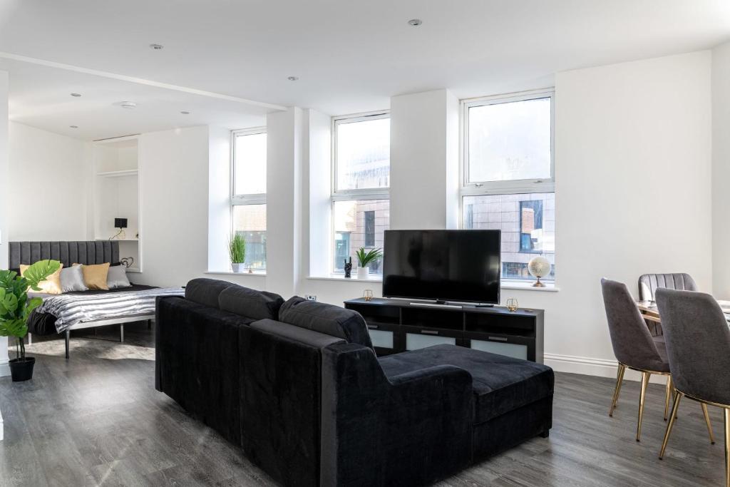 ein Wohnzimmer mit einem Sofa und einem TV in der Unterkunft Stylish Central Studio Apartment Modern Luxury in Brighton & Hove